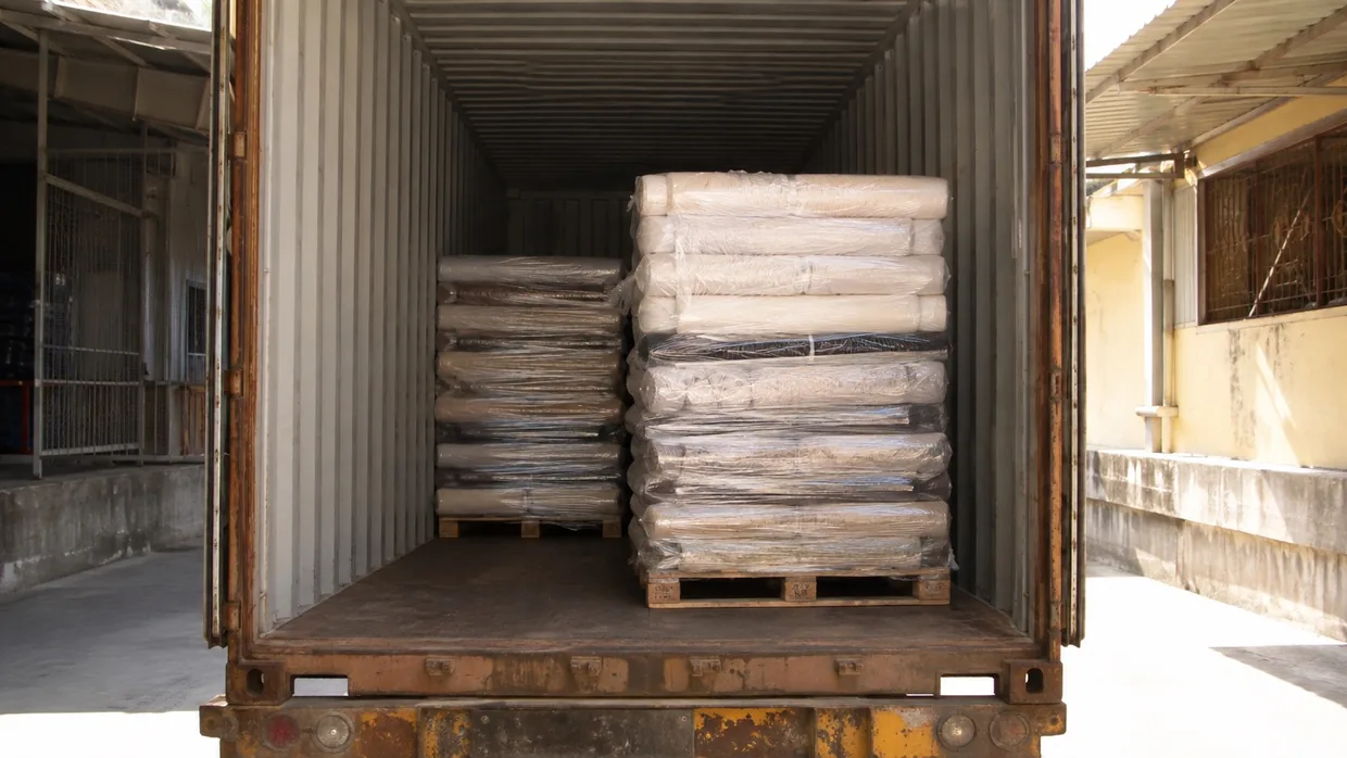 Shrink-wrapped fabric pallets loaded inside a shipping container