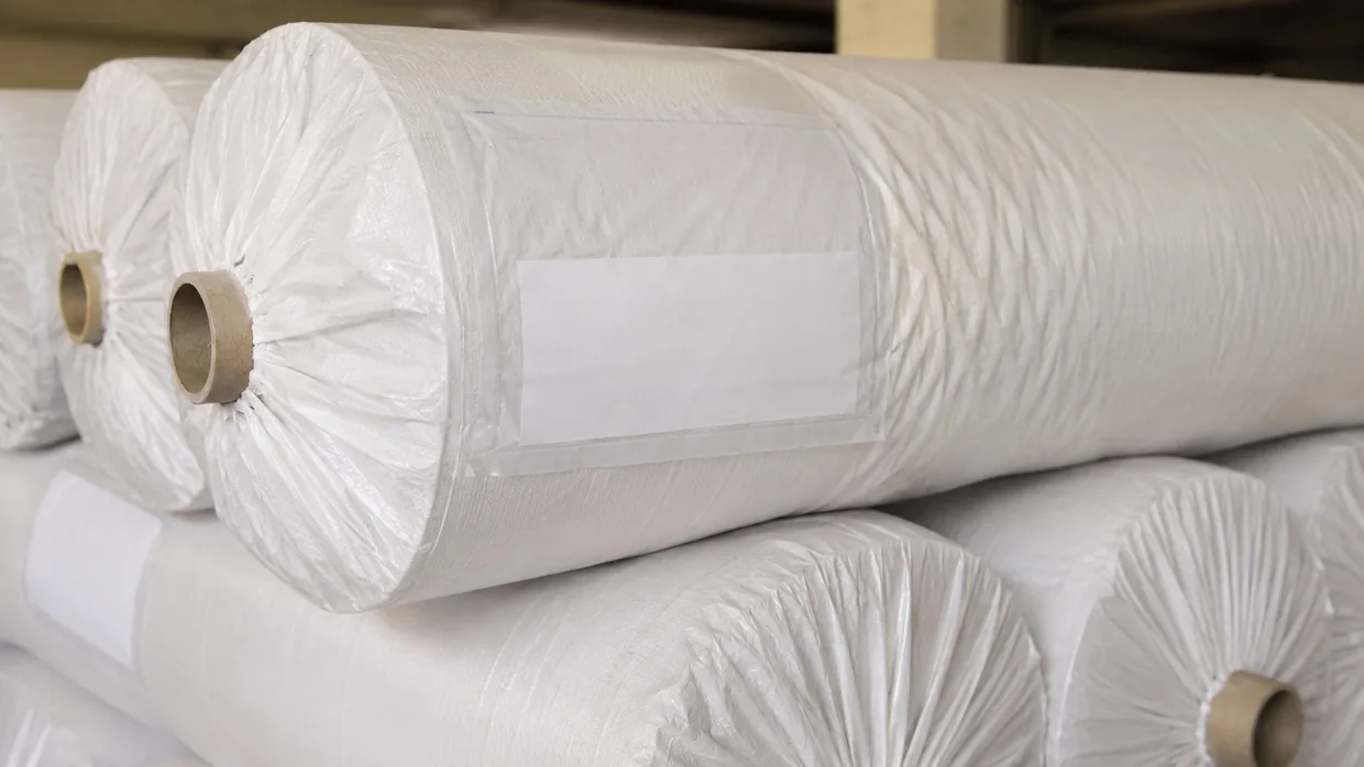 A wrapped export fabric roll with a blank shipping label pocket