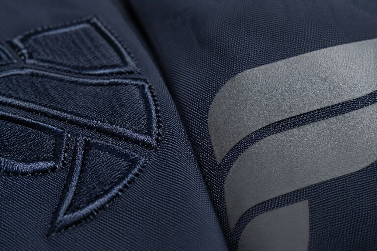 Close-up of embroidered thread and a heat-transfer print on navy uniform fabric