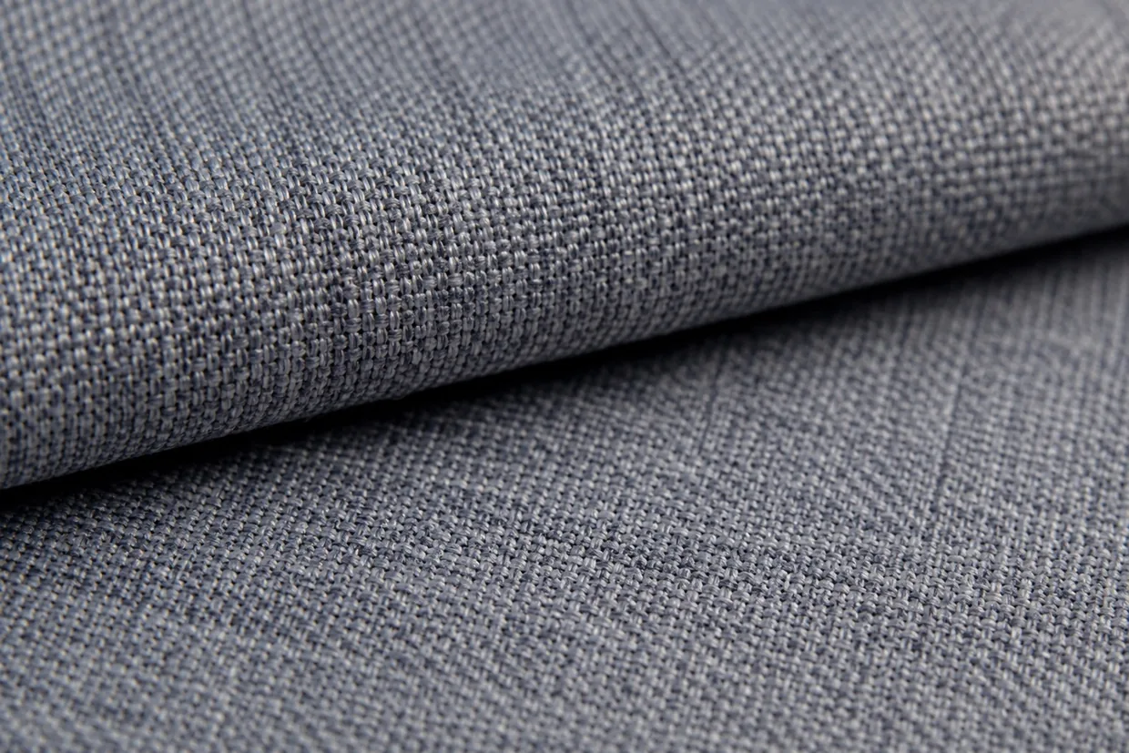 Macro close-up of grey poly-viscose blend fabric showing individual fiber threads in the weave